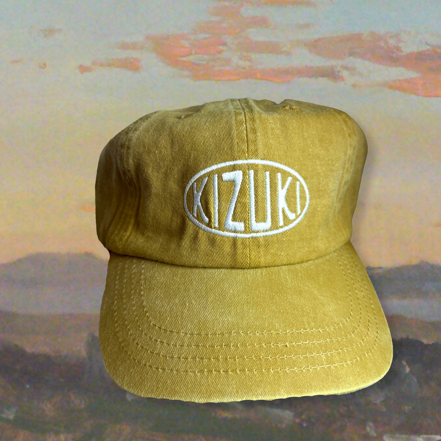 yellow cap with 'Kizuki' logo on a textured surface